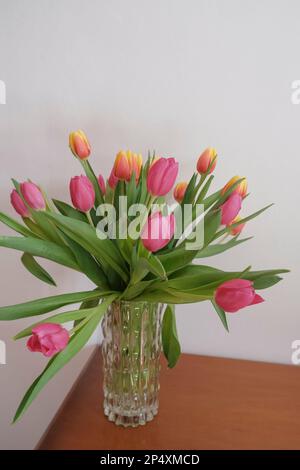 bouquet de tulipes roses et jaunes dans vase gros plan sur blanc tout sur le tiroir en bois. Détails intérieurs. Intérieur de l'hôtel Banque D'Images