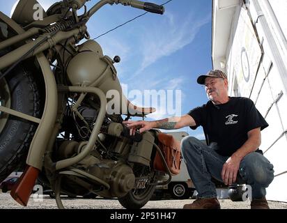 This Sept. 30, 2013 photo shows Terry Williams sharing details from his restoration of a 1942 Harley-Davidson WLA military motorcycle for owner Roger Harris in Decatur, Ill. Williams left no bolt unturned and knows pretty much everything about these bikes. He could probably field-strip and assemble one blindfolded while under fire, and is aware there’s a good chance these military machines, deployed throughout World War II, saw their share of action.(AP Photo/Herald & Review, Jim Bowling)