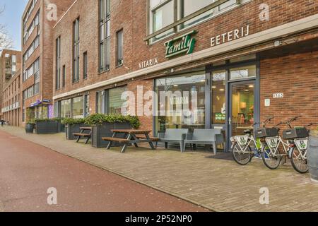 Amsterdam, pays-Bas - 10 avril 2021 : un vélo garé sur le côté d'une route en face d'un bâtiment qui est bricolé et a des fenêtres Banque D'Images