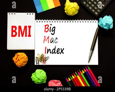 BMI gros symbole d'index mac. Concept mots BMI Big mac index sur note blanche sur fond noir magnifique. Crayon et stylo. Calculatrice. Entreprise et IMC Banque D'Images