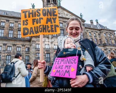 Amsterdam, pays-Bas. 05th mars 2023. Une femme et sa petite fille sont vues portant des plaques féministes pendant la manifestation. Le week-end qui a précédé la Journée internationale de la femme, la « Marche féministe » a organisé une marche appelant à un mouvement encore plus inclusif où des milliers de personnes se sont rassemblées sur la place du Dam dans le centre-ville. Crédit : SOPA Images Limited/Alamy Live News Banque D'Images