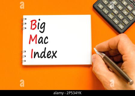 BMI gros symbole d'index mac. Concept mots BMI Big mac index sur une note blanche sur un beau fond orange. Main d'homme d'affaires. Calculatrice. Business et B Banque D'Images