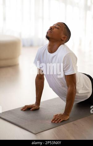 Photo verticale d'un homme noir faisant du yoga à la maison Banque D'Images