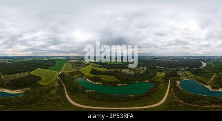 Vue panoramique à 360° de panorama aérien sans couture du hdri 360 sur une carrière inondée d'eau pour l'extraction de sable avec ciel couvert et nuages dans un spher équirectangulaire