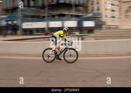 Course populaire de biathlon dans les rues de Madrid où les athlètes courent à pied et à vélo Banque D'Images