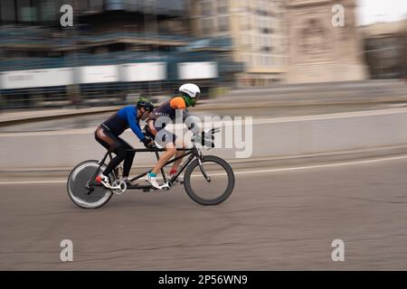 Course populaire de biathlon dans les rues de Madrid où les athlètes courent à pied et à vélo Banque D'Images