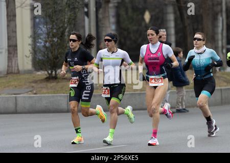 Course populaire de biathlon dans les rues de Madrid où les athlètes courent à pied et à vélo Banque D'Images