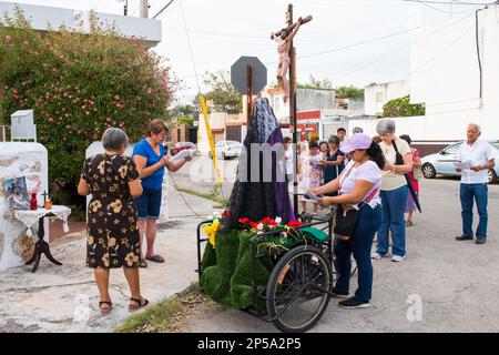 Pour marquer le septième vendredi de Carême, de petits autels d'homme sont établis dans certains des quartiers plus traditionnels de Merida, au Mexique. Ils sont ici pour commémorer la souffrance de la Vierge Marie. Les paroissiens vont de maison en maison avec une statue de la Vierge Marie et une croix avec Jésus, ils prient et chantent des cantiques religieux pour l'occasion Banque D'Images