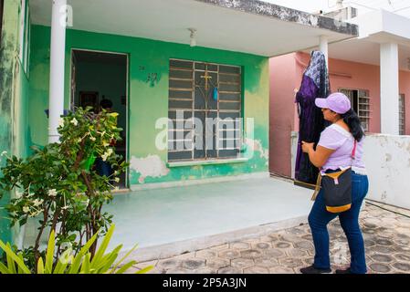 La Vierge Marie a apporté à une maison de paroissiens. Pour marquer le septième vendredi de Carême, de petits autels d'homme sont établis dans certains des quartiers plus traditionnels de Merida, au Mexique. Ils sont ici pour commémorer la souffrance de la Vierge Marie. Les paroissiens vont de maison en maison avec une statue de la Vierge Marie et une croix avec Jésus, ils prient et chantent des cantiques religieux pour l'occasion. Chaque semaine, la statue de la Vierge Marie est abritée dans une maison différente. Banque D'Images