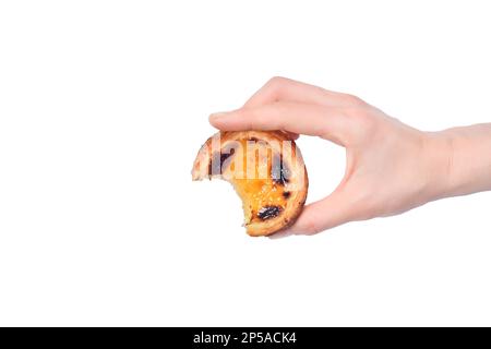 Moitié mangé pastel de nata à la main gros plan sur fond blanc. Tarte aux œufs, dessert portugais traditionnel. Banque D'Images