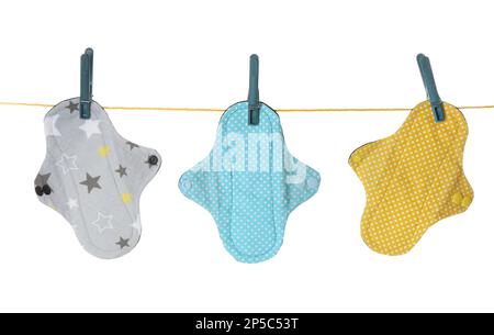 De nombreux tapis menstruels en tissu différents suspendus isolés sur blanc Banque D'Images