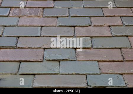 Carreaux de parement en ardoise sur le mur d'un bâtiment en Nouvelle-Angleterre. Il existe une gamme de couleurs, de textures et de formes rectangulaires. Banque D'Images