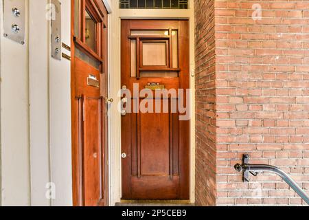 une entrée à une maison avec un mur de briques rouges et une bordure blanche sur la porte, qui est fermée Banque D'Images