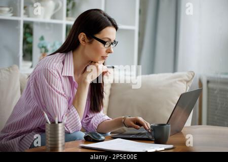 Photo d'une jeune femme d'affaires attirante travaillant sur un ordinateur portable dans son poste de travail. Banque D'Images