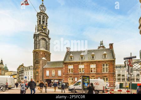 Amsterdam, pays-Bas - 10 avril 2021 : certaines personnes se promo devant un bâtiment avec une horloge sur son visage et le ciel est bleu Banque D'Images