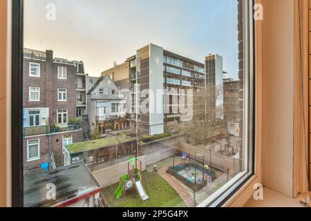 vue depuis la fenêtre d'un immeuble avec des enfants jouant dans la cour et de l'autre côté de la maison Banque D'Images