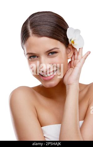 Beauté insouciante. Studio portrait d'une belle jeune femme avec une orchidée dans ses cheveux. Banque D'Images