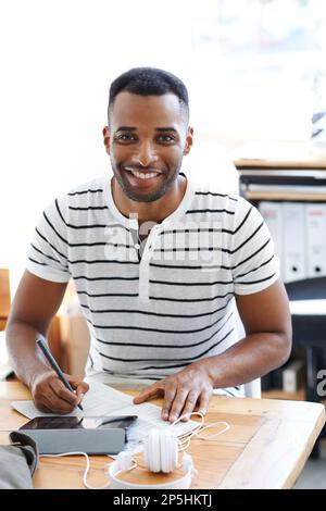 Faire une étude de marché. Un beau homme afro-américain travaillant sur une tablette numérique dans son bureau. Banque D'Images