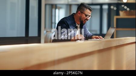 Dessin professionnel sur une tablette graphique dans un café. Homme d'affaires créatif travaillant sur un nouveau design avec un ordinateur portable. Travail de concepteur Web freelance Banque D'Images