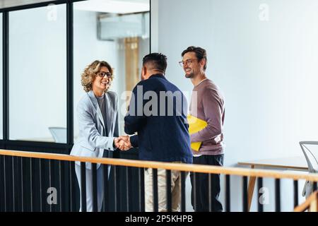 Une femme d'affaires réussie se serrer la main avec un nouveau client dans un bureau. Une femme professionnelle rencontre un partenaire commercial potentiel. Partenariat dans un Banque D'Images