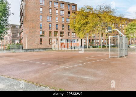 Amsterdam, pays-Bas - 10 avril 2021 : un court de tennis vide au milieu d'une zone résidentielle avec des arbres et des bâtiments de chaque côté de la rue Banque D'Images