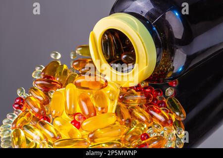 Gros plan sur le flacon renversé avec pile de pilules de vitamine. Capsules de vitamines Omega. Banque D'Images