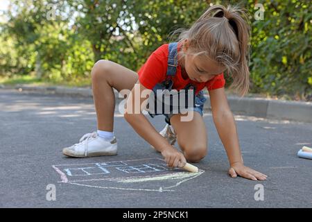 Jolie petite maison de dessin d'enfant avec craie colorée sur l'asphalte Banque D'Images