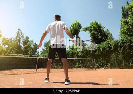 Homme jouant au tennis sur le court, vue arrière Banque D'Images