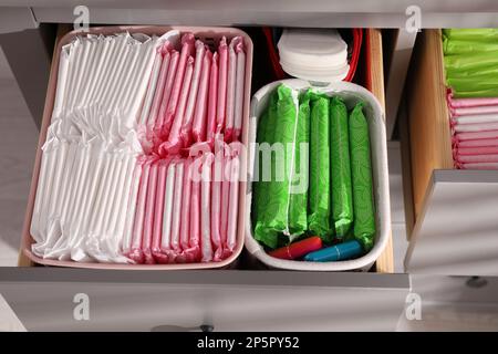 Ouvrez les tiroirs de l'armoire avec les tapis menstruels, les tampons et les pantyliners à l'intérieur, au-dessus de la vue Banque D'Images