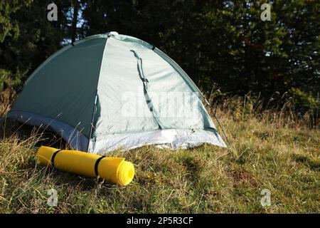 Tapis de couchage près d'une tente de camping à l'extérieur. Équipement de tourisme Banque D'Images