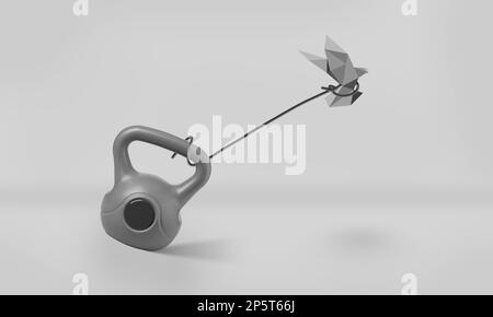 Origami oiseau essayant à peine de voler tout en étant attaché à Un poids lourd de Kettlebell. Concept de restriction, de liberté, de lutte et de défi Banque D'Images