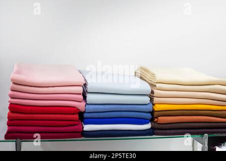 des articles en laine multicolores magnifiquement pliés en piles. armoire Banque D'Images