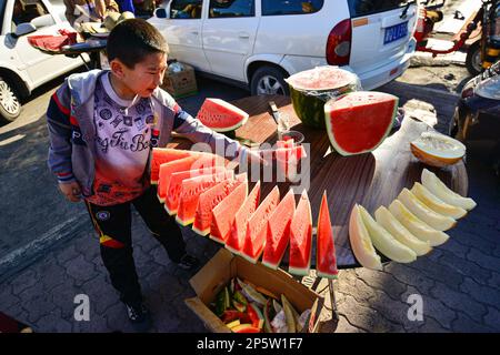 Vendeurs de pastèques sur un marché à Urumqi, Xinjiang, Chine Banque D'Images