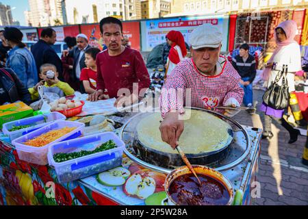 Vendeurs de crêpes sur un marché traditionnel en plein air à Urumqi, Xinjiang, Chine Banque D'Images