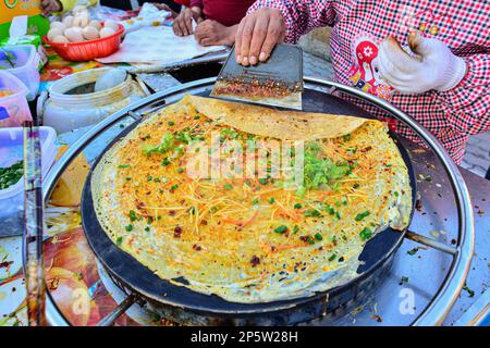 Vendeurs de crêpes sur un marché traditionnel en plein air à Urumqi, Xinjiang, Chine Banque D'Images