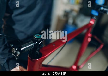 Mécanicien réparateur assemblant la fourche en carbone avec une clé de vélo personnalisée en atelier Banque D'Images