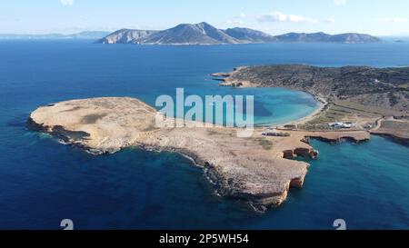 Image aérienne des grottes de Ksylompatis en direction de la plage de Pori où est ancré un bateau à voile, avec l'île Amorgos en arrière-plan. Banque D'Images