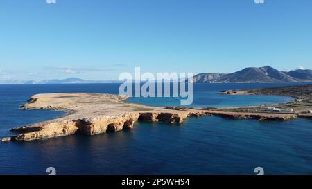Image aérienne des grottes de Ksylompatis en direction de la plage de Pori où est ancré un bateau à voile, avec l'île Amorgos en arrière-plan. Banque D'Images