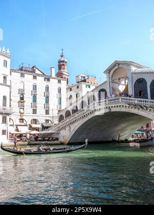 Des gondoles et des bateaux flottent sur le magnifique Grand Canal dans Venise ensoleillée, en Italie, avec des palais traditionnels en arrière-plan. Banque D'Images