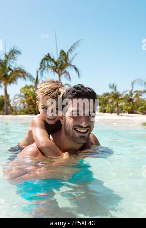 Portrait du père et du fils heureux d'oiseaux jouant ensemble dans la piscine Banque D'Images