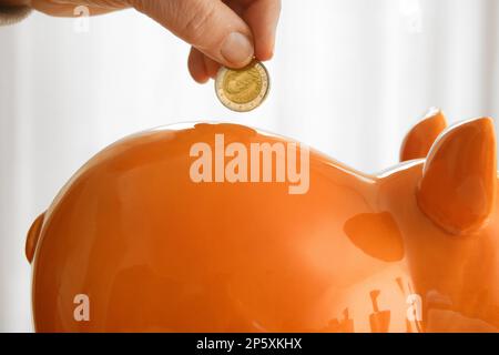 Mettre un euro dans une porcgybank Banque D'Images