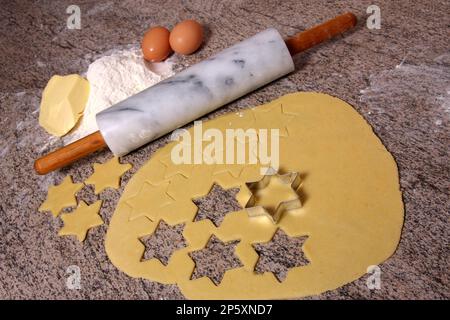 En faisant cuire des biscuits de Noël, les étoiles sont piquées de la pâte Banque D'Images