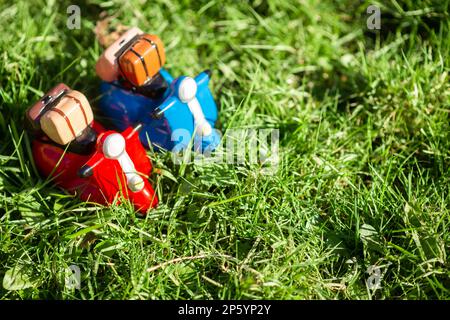 Le concept de voyager sur des cyclomoteurs au printemps ou en été. Figurines de mobylette sur l'herbe verte au soleil. Banque D'Images