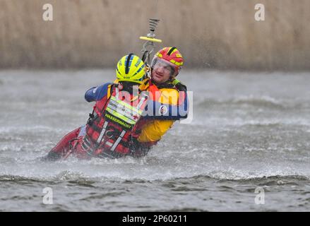 07 mars 2023, Brandebourg, Francfort (Oder): Au cours d'un exercice de sauvetage en eau, deux personnes sont tirées de la frontière germano-polonaise Oder par un hélicoptère de la Bundeswehr. Le même jour, l'escadron aérien de la police fédérale de Blumberg, avec la Croix-Rouge allemande (DRK), les forces armées allemandes et Wasserwacht, ainsi que les unités de secours polonaises, ont mené un exercice conjoint pour sauver des personnes des eaux coulantes sur la rivière Oder. Les sauveteurs aériens bénévoles du sauvetage en eau du DRK pratiquent régulièrement selon un concept coordonné avec la police fédérale. La coopération a été lancée après Banque D'Images