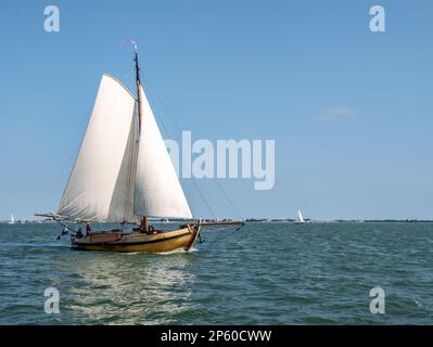 Petit voilier traditionnel classique naviguant sous des voiles complètes sur le lac Ijsselmeer, pays-Bas Banque D'Images