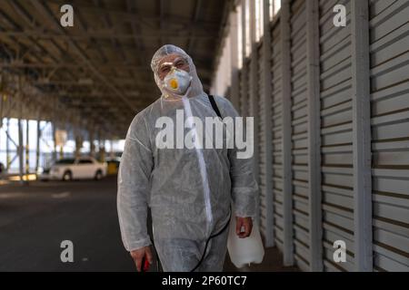 Désespéré travailleur de santé dans des combinaisons de protection blanches covid.fatigué Homme le médecin caucasien saisit sa tête cower dans la dépression pendant la pandémie de coronavirus Paramedic surtravaillé pleurer couvert visage avec les mains Banque D'Images