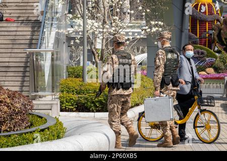 SHANGHAI, CHINE - 7 MARS 2023 - deux policiers chinois armés patrouillent la rue Lujiazui à Shanghai, Chine, le 7 mars 2023. Banque D'Images