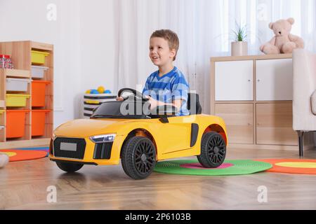 Petit enfant jouant avec une voiture-jouet dans la chambre Banque D'Images
