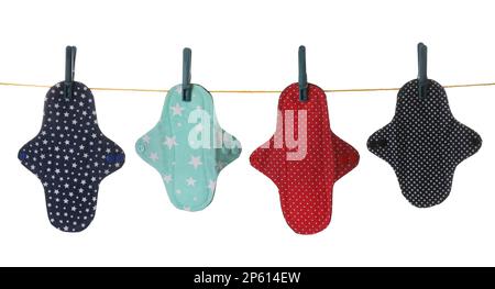 De nombreux tapis menstruels en tissu différents suspendus isolés sur blanc Banque D'Images