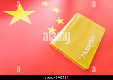 Drapeau de la chine avec passeport. Concept de visa de voyage et de citoyenneté. permis de séjour dans le pays. un document jaune avec l'inscription passeport est Banque D'Images